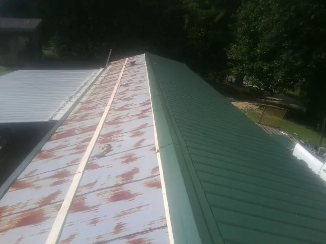 Old rusted panels beside newly installed green metal roofing — Wind Damage Roof Repair by Roofing Brothers in Hawthorne